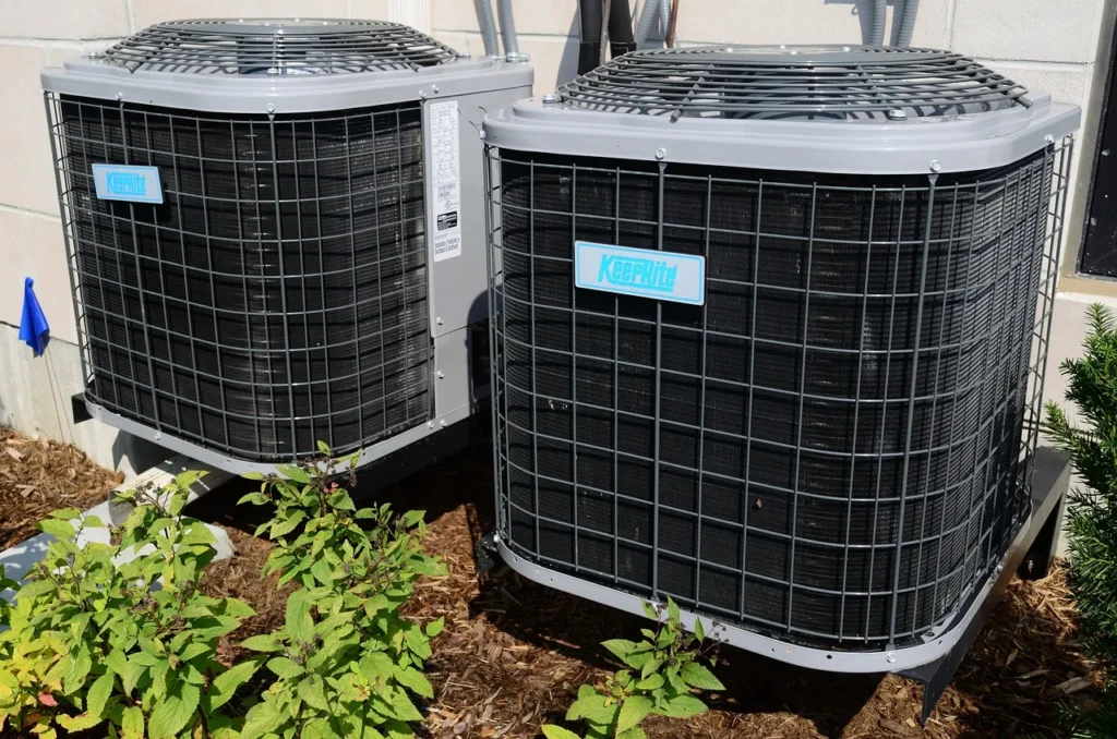Two outdoor air conditioner condenser units beside a building